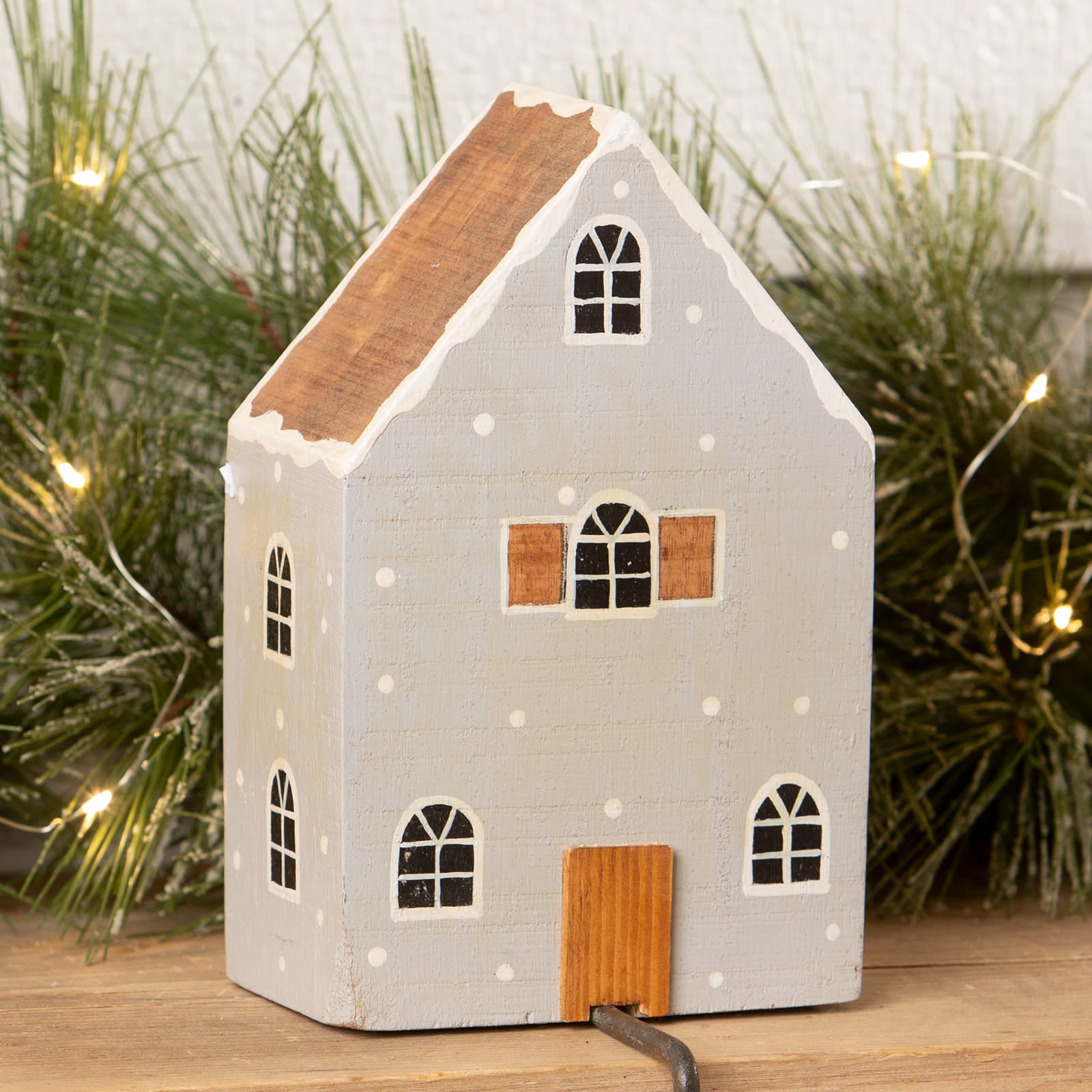 A charming light-up gray house stocking holder with wood details and snow-dusted trim for christmas stockings