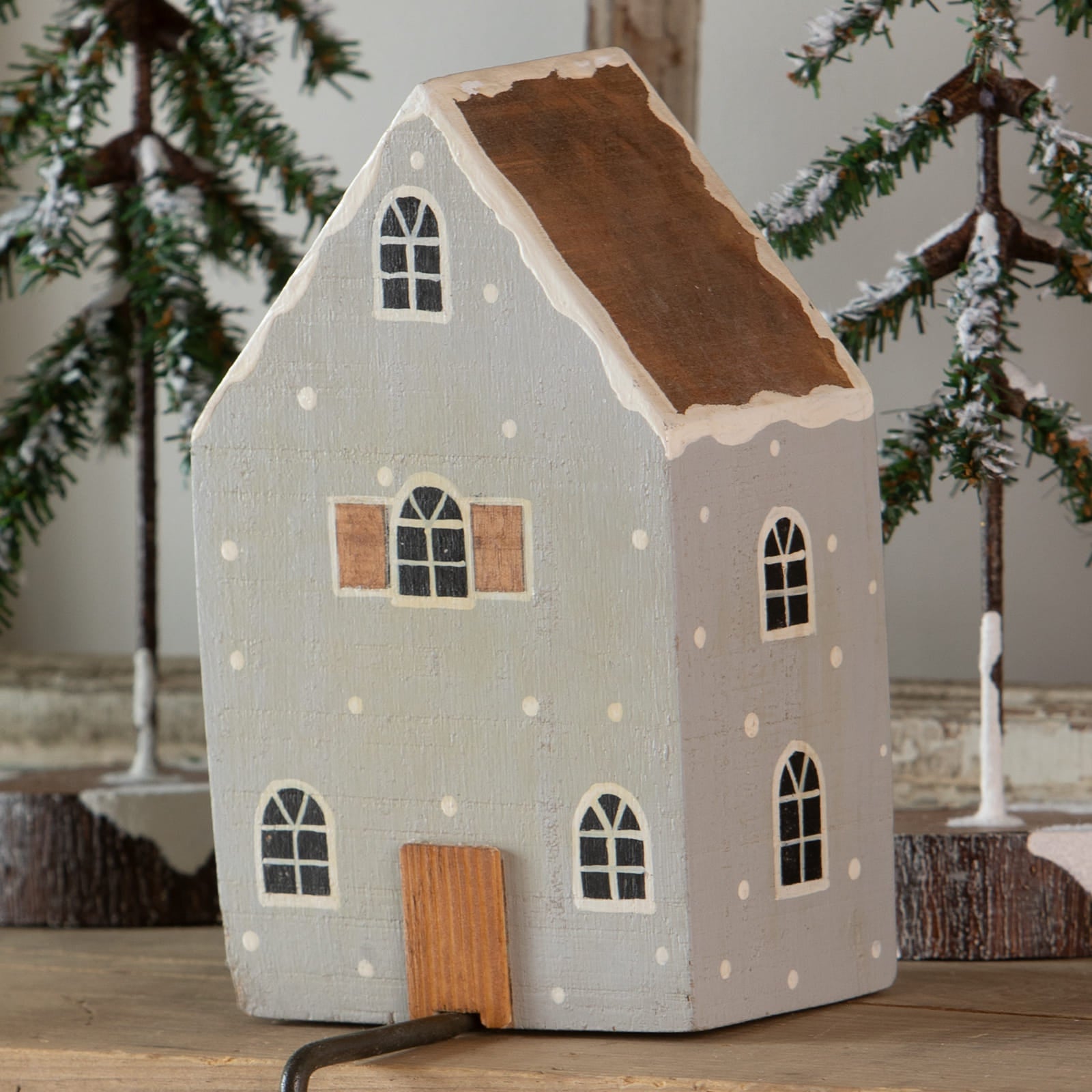 A charming gray house stocking holder with light-up wooden design, brown roof, and white polka dots for christmas stockings