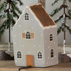 A charming gray house stocking holder with light-up wooden design, brown roof, and white polka dots for christmas stockings