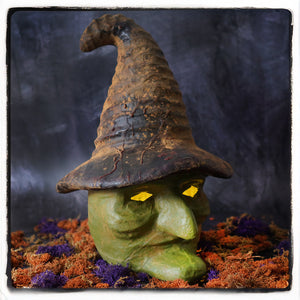 Green witch head figurine with glowing yellow eyes and tall cracked brown hat perfect for halloween witches decor
