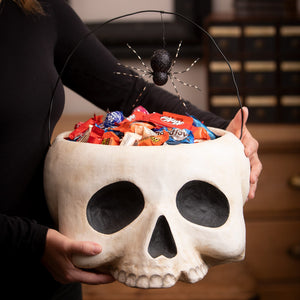 White skull-shaped grim bucket halloween bucket with black sockets and glittery spider on wire handle for skeleton decor ornaments
