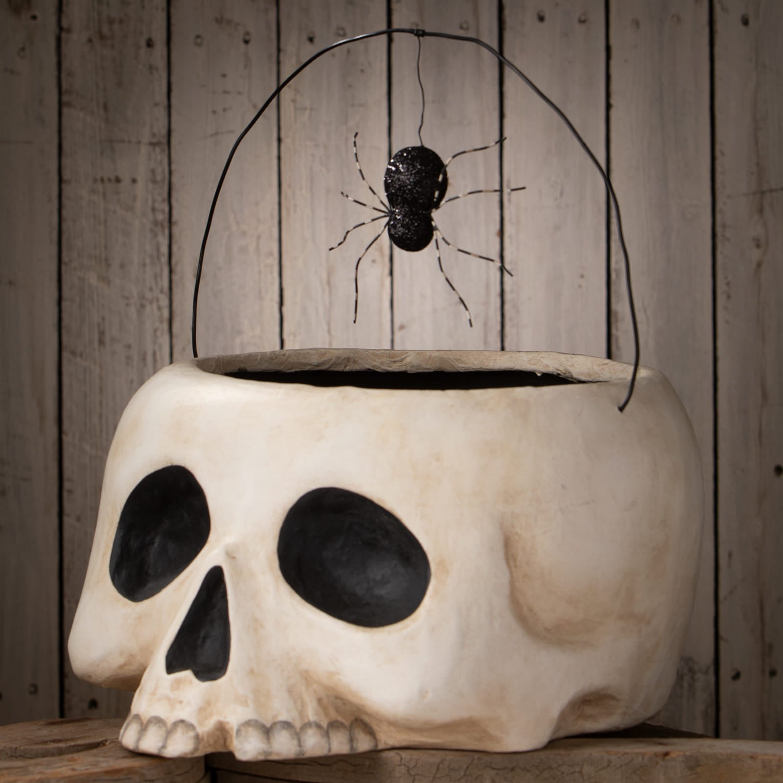 White plastic grim bucket halloween bucket with skull shape black eye sockets and glittery spider handle perfect for skeleton decor figures and ornaments