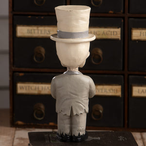 White sculpted skelly skeleton decor figure wearing a gray band top hat and matching suit called groom mortimer skelly