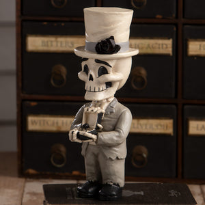 Groom mortimer skelly skeleton decor figure in gray suit and top hat with black rose holding small object