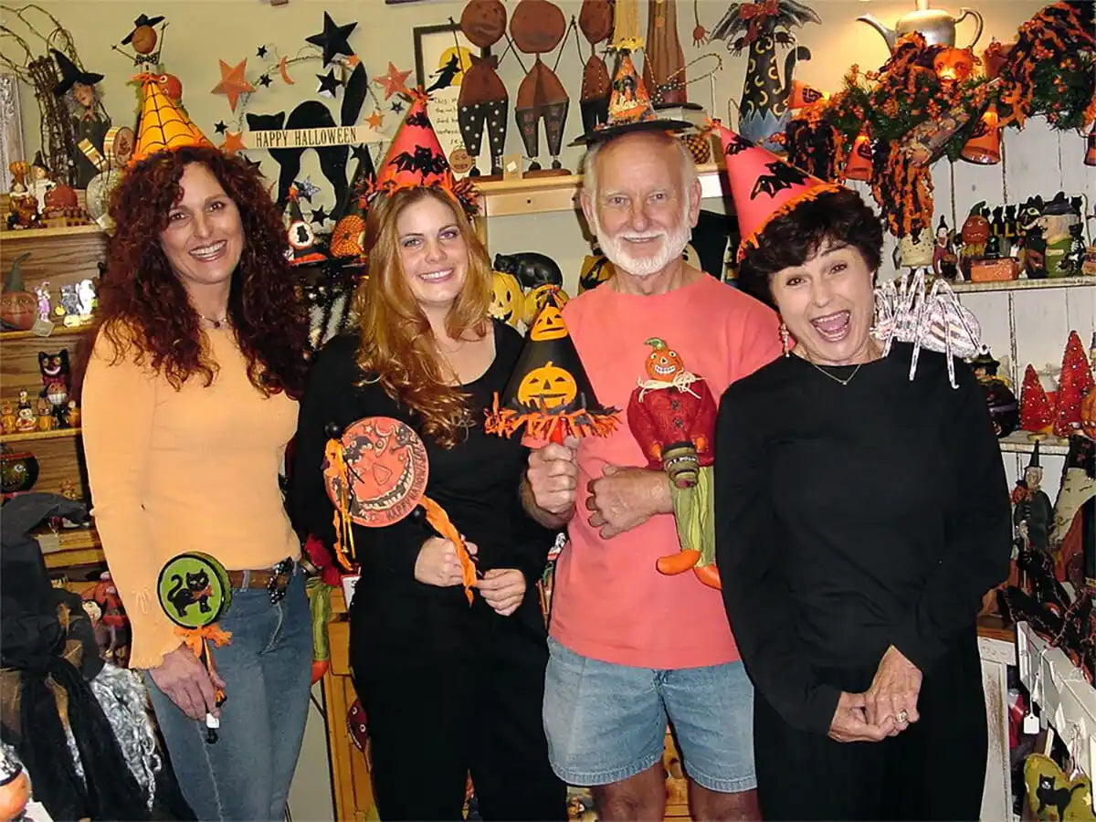 A group of people wearing Halloween-themed clothing and accessories while posing together.