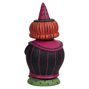 A whimsical witch figurine from the jack spooks jar with a vibrant pink hat and jack o lantern inspired stripes