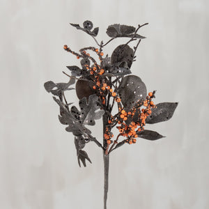 A halloween berry floral pick with dark glittery leaves and clusters of bright orange artificial berries