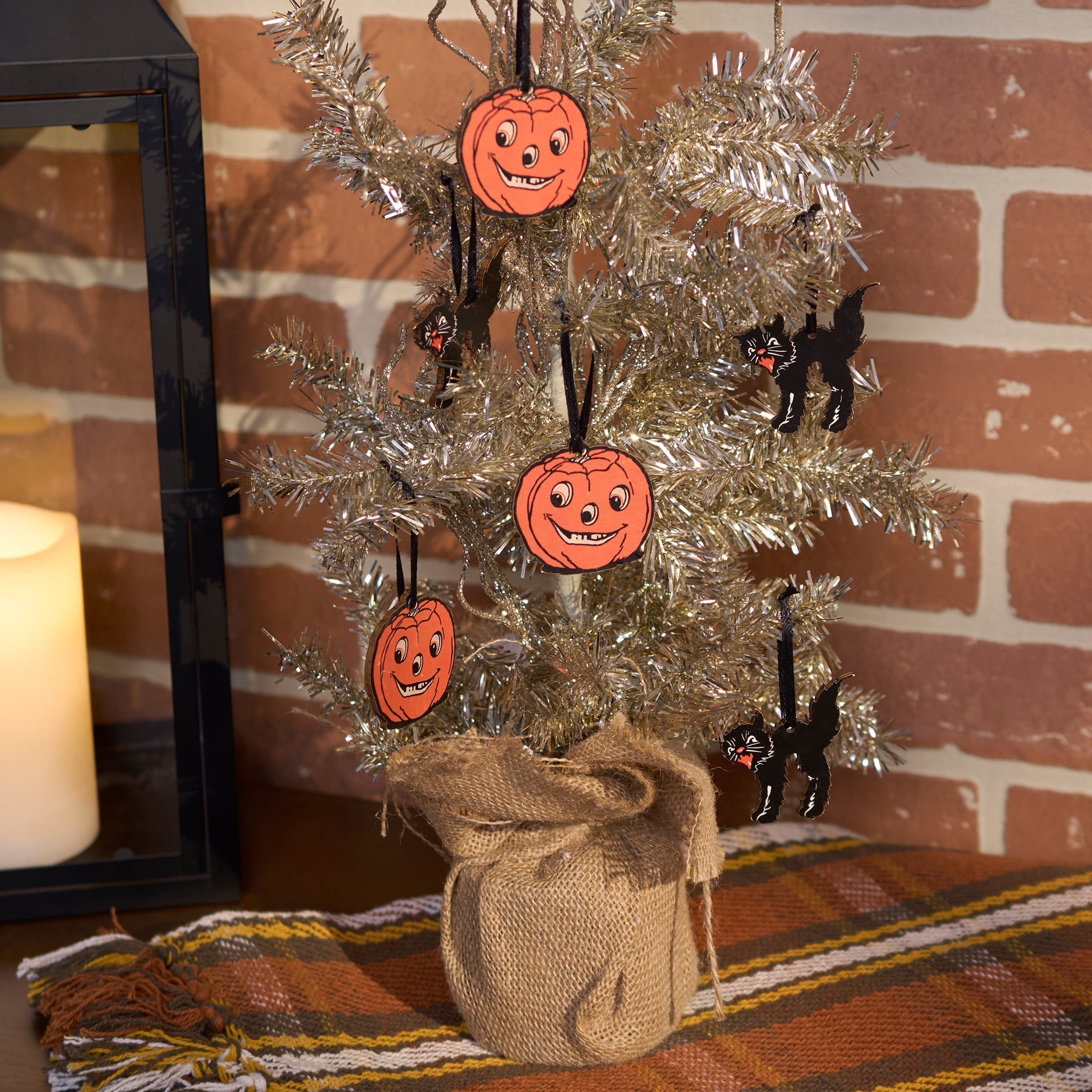 A halloween mini ornament set featuring a silver tinsel tree with orange pumpkin and black cat mini ornaments wrapped in burlap