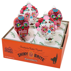 Vibrant red and white glossy dead skulls ornaments with floral patterns and sparkles perfect for tabletop decor set of 4