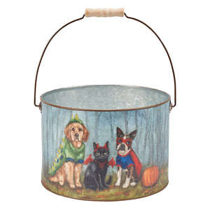 A painted metal halloween family bucket with wooden handle featuring three costumed dogs and a cat in a halloween forest scene