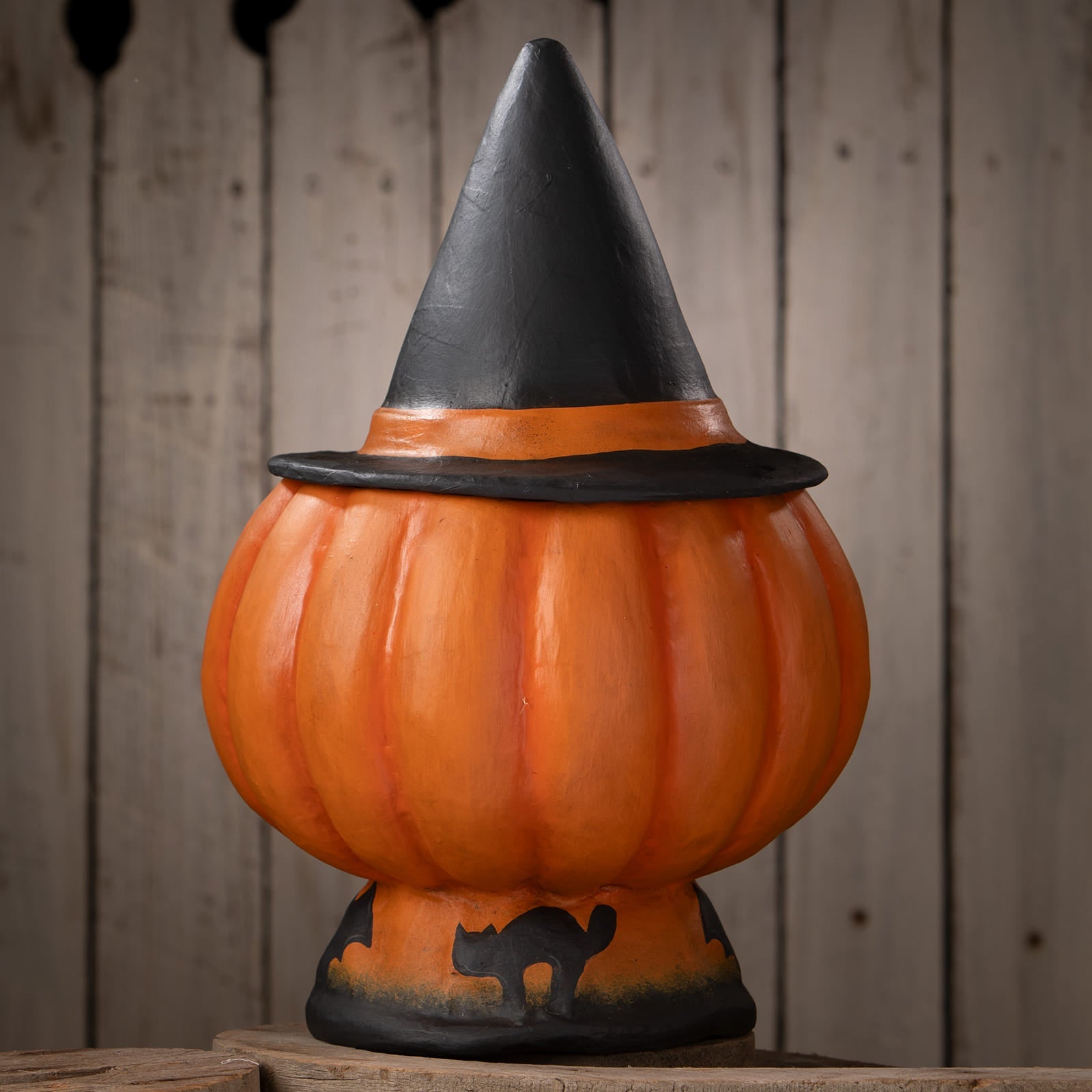 Orange halloween pumpkin decoration shaped like a jack o lantern with a black witch hat and cat design