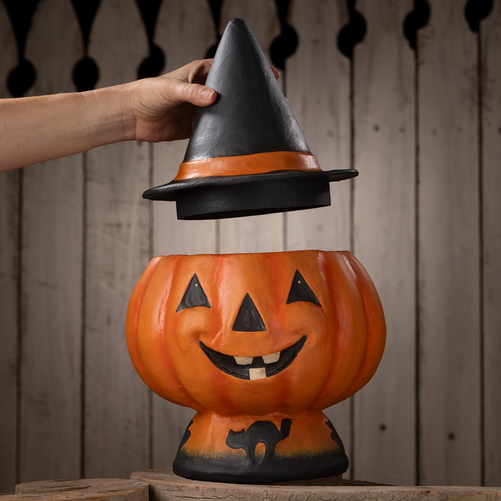 Orange plastic halloween jack o lantern candy bucket with black witch hat lid featuring cutout eyes and mouth