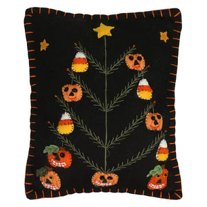 Black halloween pillow featuring a halloween tree decorated with candy corn and pumpkins design with orange stitching