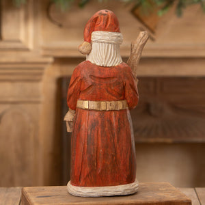 Hand carved santa figure in red coat with white beard holding a branch perfect for folk art santas collections
