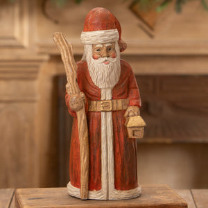 Hand carved santa with staff in red coat white beard holding rustic stick and lantern perfect folk art santas figure