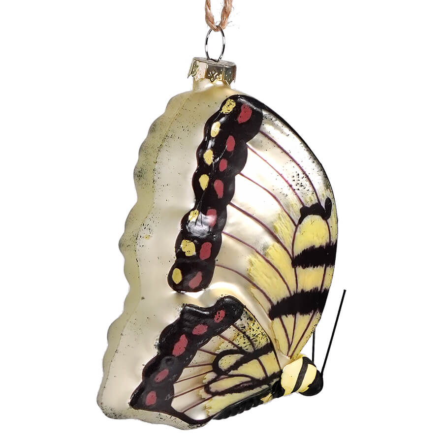 Butterfly-shaped glass Christmas ornament with delicate wing patterns.