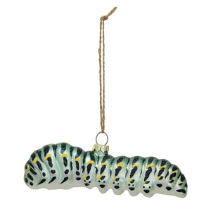Glass caterpillar ornament with black and yellow markings on a pale green body, suspended by a string.