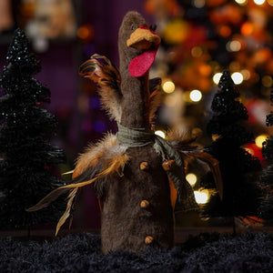 A handcrafted baby bird turkey plush in brown felt with bright red wattle orange beak feathers and wooden buttons