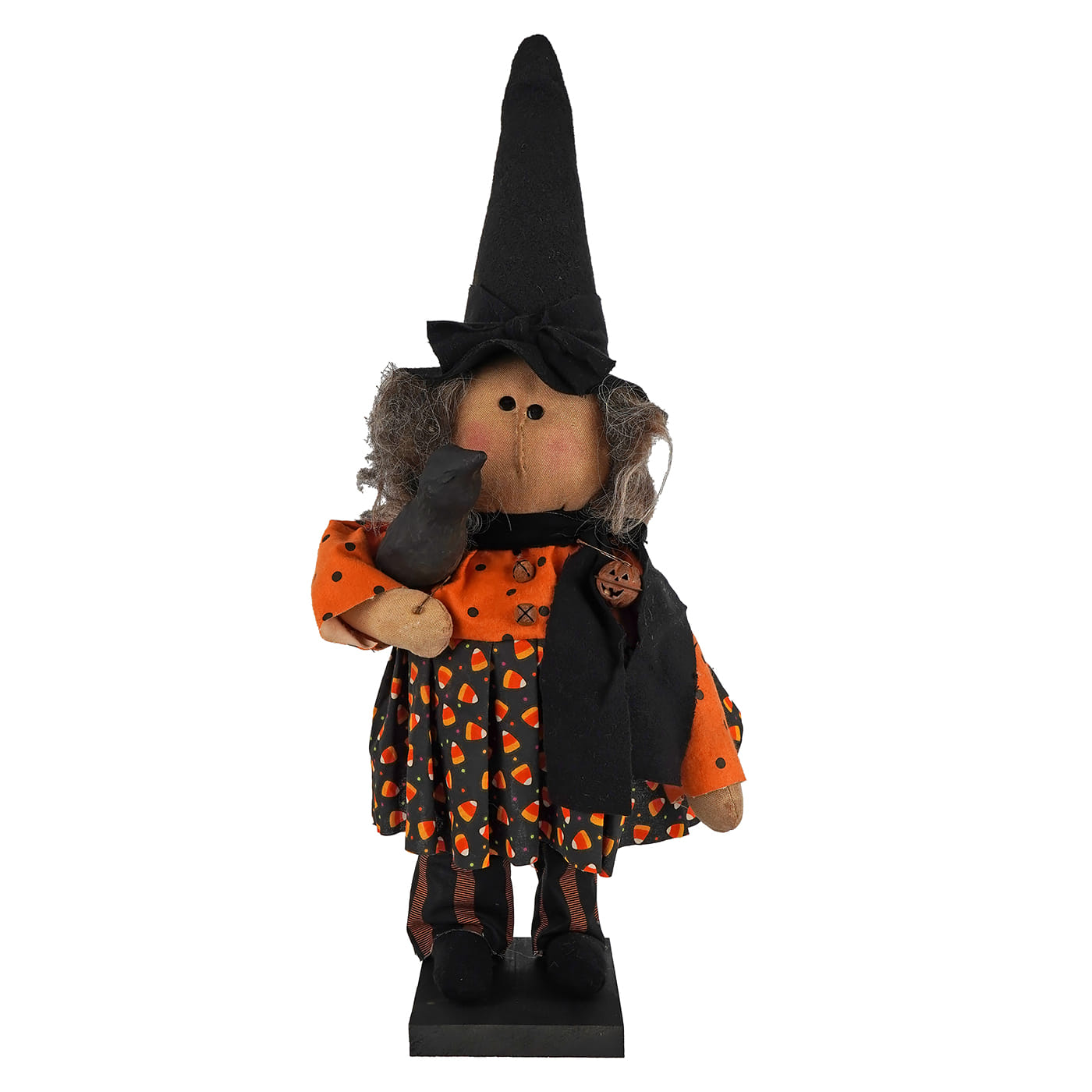 A plush handcrafted large standing candy corn dress witch figurine with a tall black hat and crow for figural decor