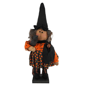 A plush handcrafted large standing candy corn dress witch figurine with a tall black hat and crow for figural decor