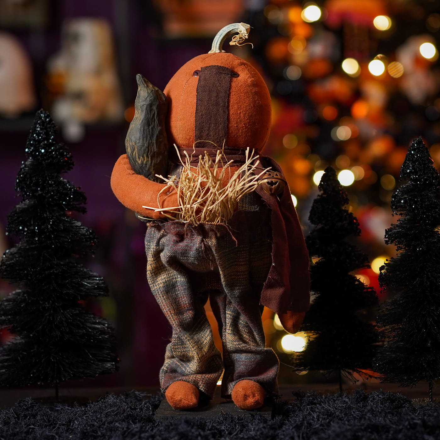 Handcrafted large standing fall colors scarecrow with orange pumpkin head and patchwork pants for figural decor or tree toppers