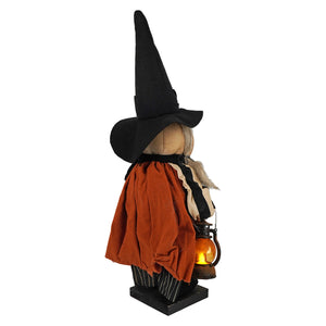 Handcrafted large standing pumpkin witch figurine decor with tall black hat, orange cape, striped pants, and lantern light