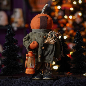 Handcrafted large standing orange pumpkin-headed scarecrow figurine in a green coat holding an orange lantern