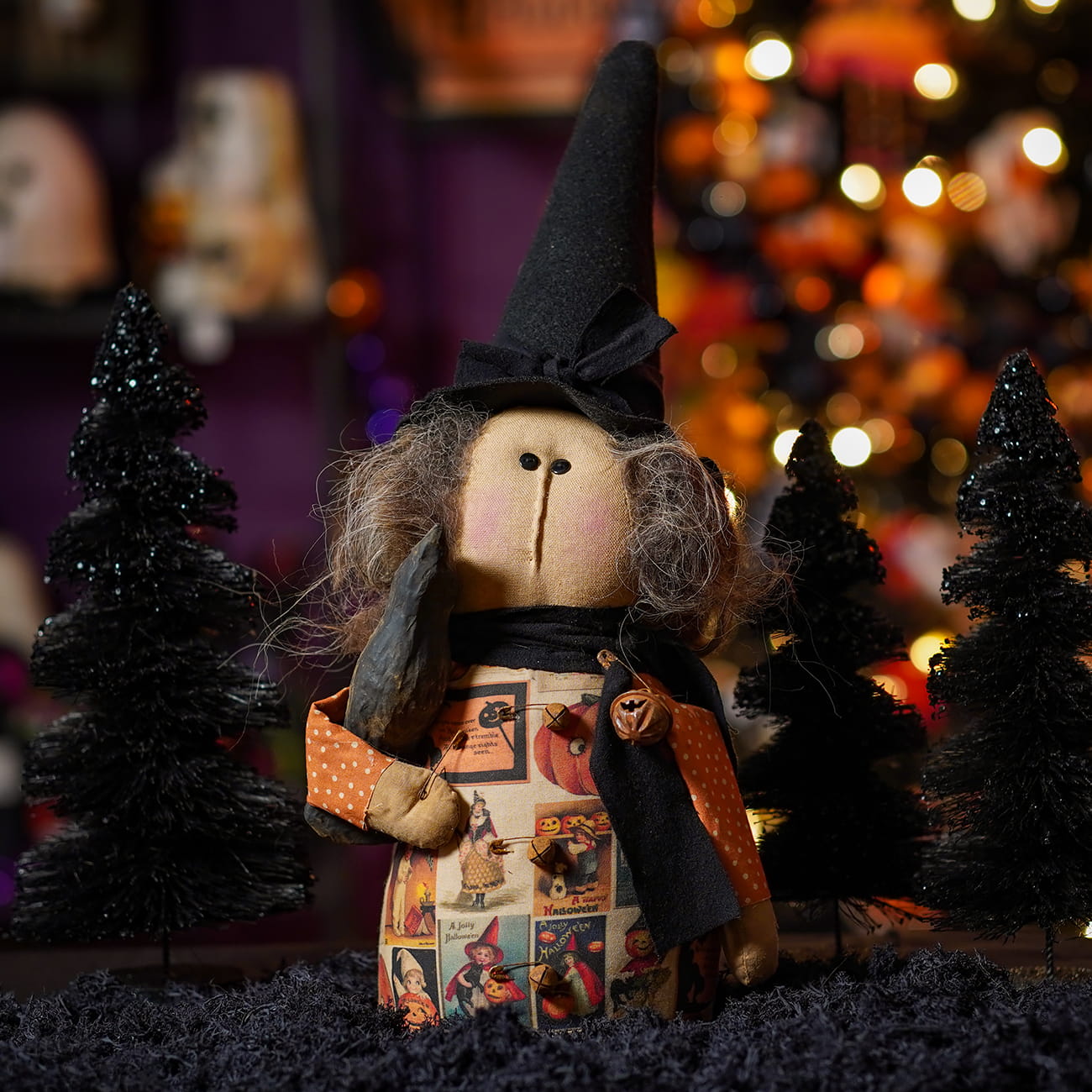 Handcrafted bertha vintage witch doll with tall black hat patchwork dress and textured gray yarn hair holding crow lighted decor