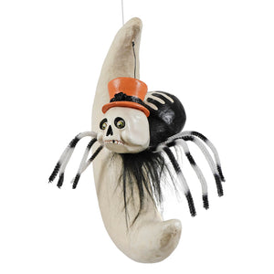 A spooky skeleton spider with black and white striped legs wearing an orange top hat perched on a cream crescent moon spider on moon