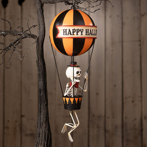Happy halloween balloon with orange and black stripes, skeleton decor figure, glittery accents, and jack o lantern banner