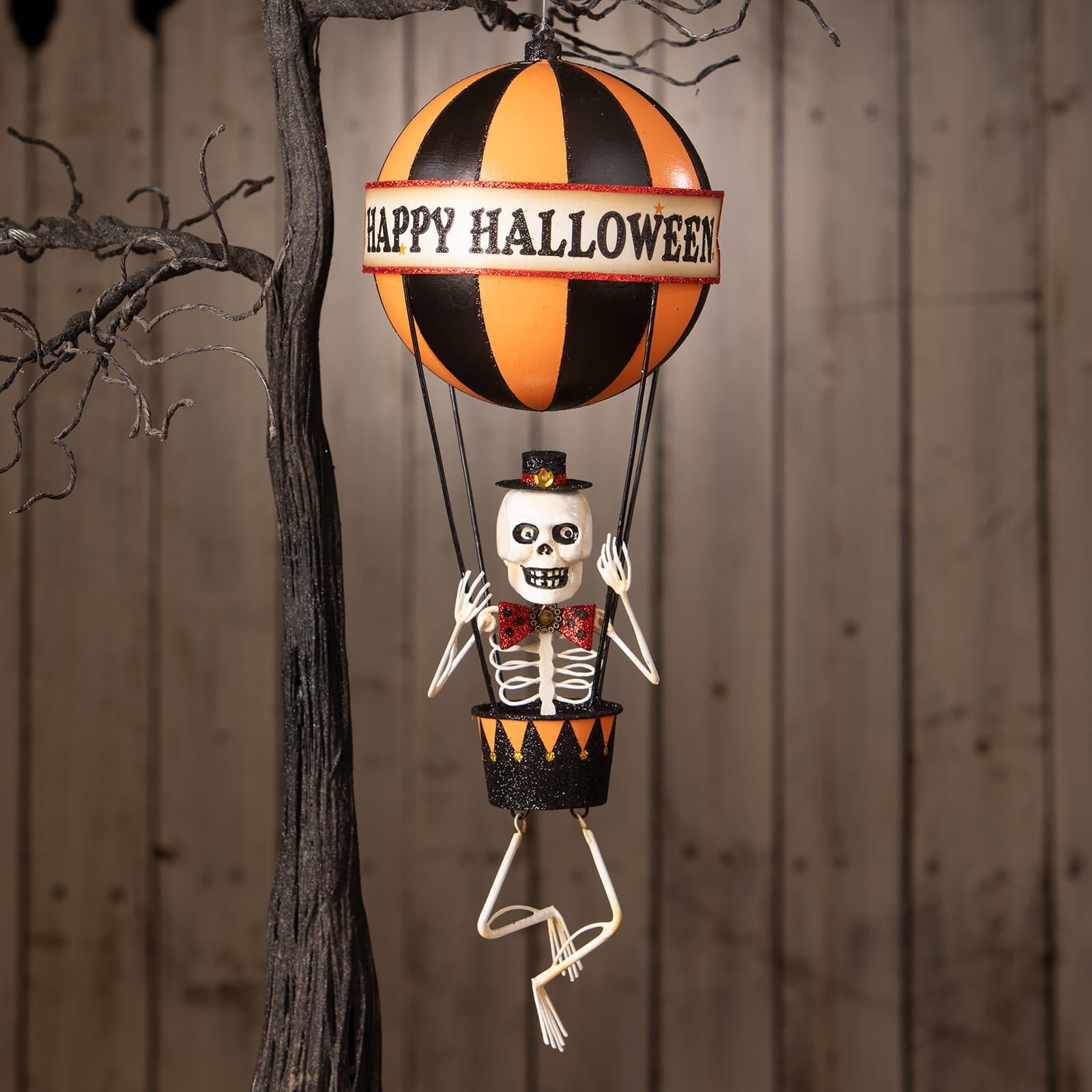 Happy halloween balloon with orange and black striped hot air balloon and skeleton decor figure in top hat and bow tie