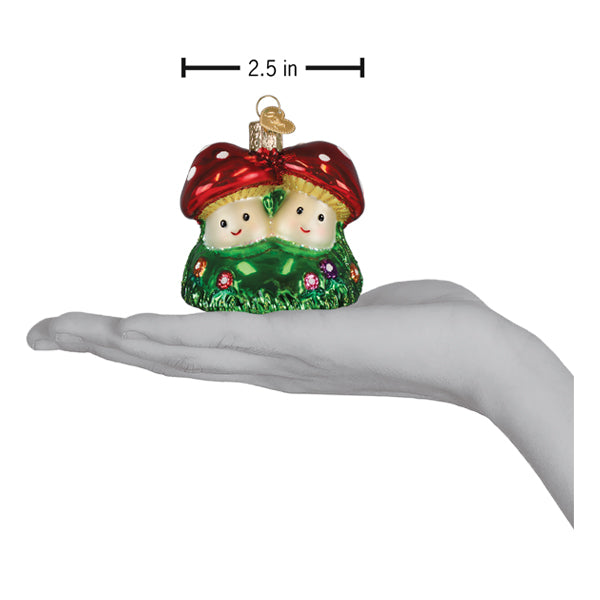 Red and white polka-dotted mushroom house ornament glass christmas glass ornament with smiling faces held in hand