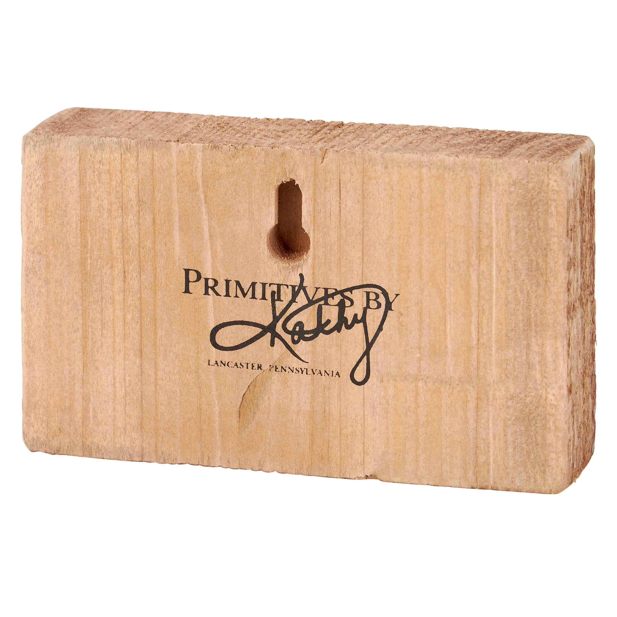 Wooden block with ’Primitives by Kathy’ text from Lancaster, Pennsylvania engraved on it.