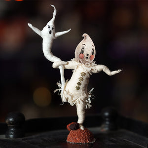 A whimsical white paper-mâché ghost with painted face and frayed lace on red base from johanna parker design haunting ghosts