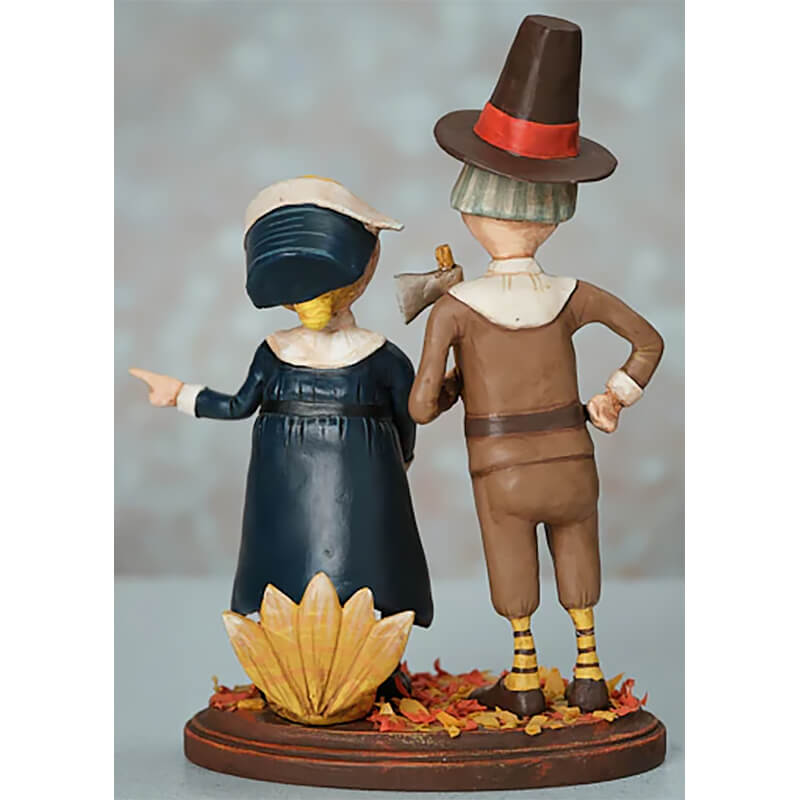 Decorative Thanksgiving figurine featuring a pilgrim couple standing among autumn leaves.