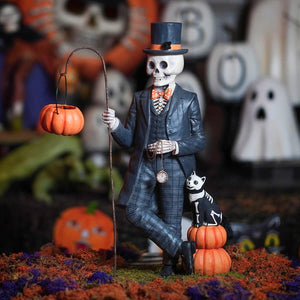 A sophisticated black henry deadison skeleton figurine in a suit and top hat holding a pumpkin lantern on a curved stick