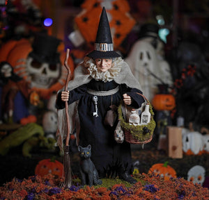 A detailed halloween witch figurine named hildegard wearing a black hat and holding a potion basket with bottles