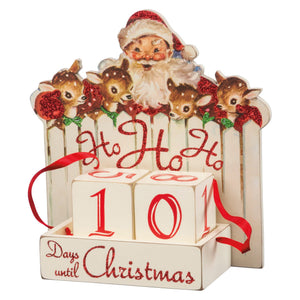 A festive white wooden block countdown with red glittery ho ho ho lettering and santa and deer design on top