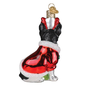 A glossy red and black glass french bulldog ornament with a seated dog in a festive santa pet outfit