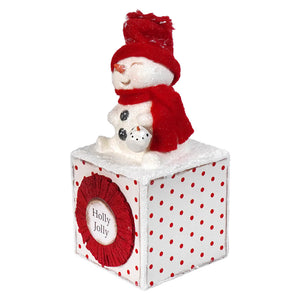 A festive red and white holly jolly snowgirl ornament with a plush snow girl on a polka dotted holly jolly cube perfect for christmas snowman figures and decor