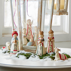 Nativity scene with decorative figurines arranged on a snowy surface.
