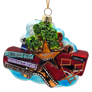 Colorful glass hollywood ornament shaped like a movie star with palm trees and street signs for figural decor or tree toppers