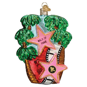 A vibrant hollywood walk of fame ornament glass ornament with pink stars gold trim and palm trees for christmas decor