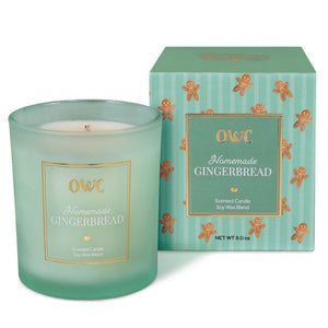 A mint green frosted glass homemade gingerbread candle with white wax and gold foil label from creative co-op