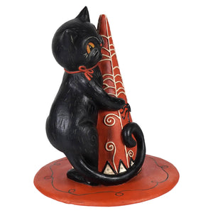 Hugga-hat jack cat black cat figurine with orange eyes and red bow sitting by red jack o lantern witch hat with white swirls