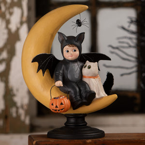 A glossy black bat-themed child figurine with white cat on yellow moon base holding orange pumpkin basket halloween figural decor