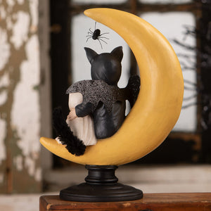 Black cat figurine with glittery wings and spider on its back sitting on a yellow crescent moon base halloween figural decor