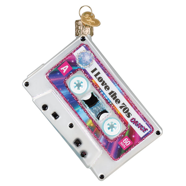 A glittery translucent white glass 70s ornament shaped like a cassette tape with rainbow sparkles for world christmas