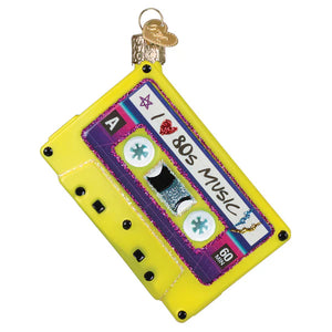 Vibrant yellow glass christmas ornament shaped like a cassette tape with purple glittery label and silver stars, 80s ornament