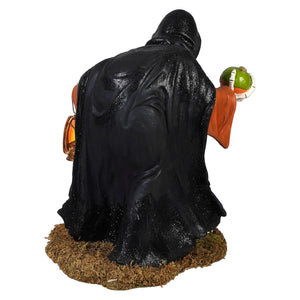 Black glossy igor skeleton figurine of a hooded figure holding an orange lantern and green pumpkin